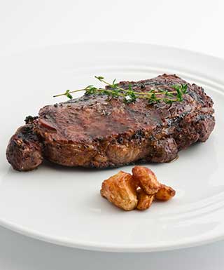 ribeye steak and vege on white plate with white background