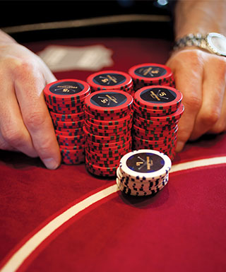 hands pushing red and white chips on red table