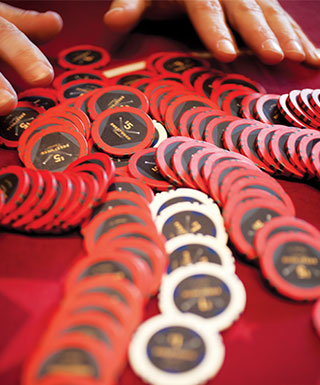 hands with scattered chips on red table