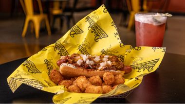 Loaded chili dog with alcoholic beverage