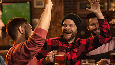 Two men cheering at the bar