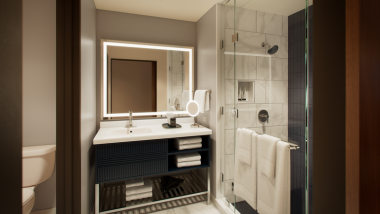 a blue and grey tile bathroom with mirror and shower
