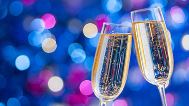 two champagne flutes toasting with a blue background